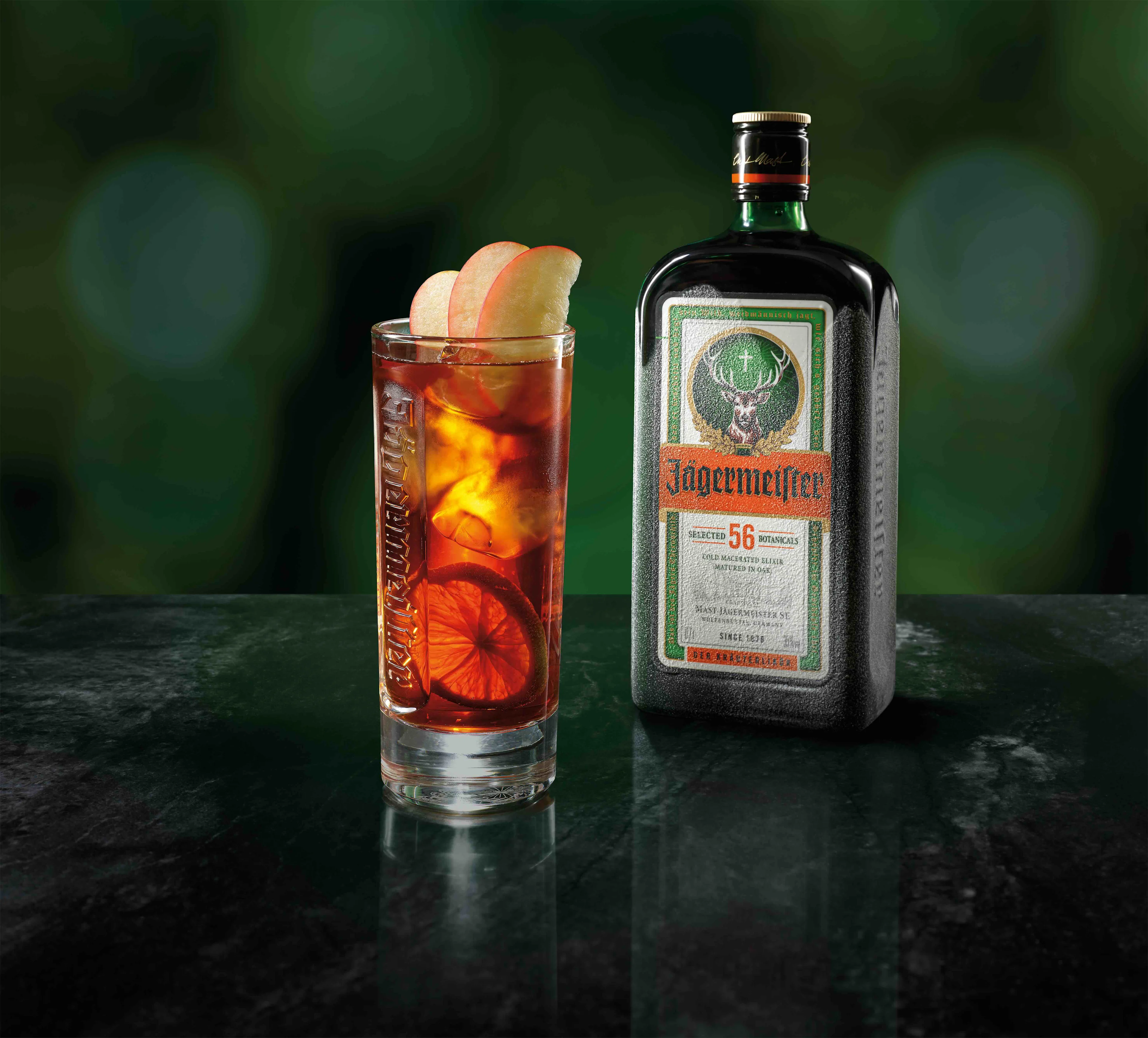 A glass of Jägermeister Dude in front of a Jägermeister bottle