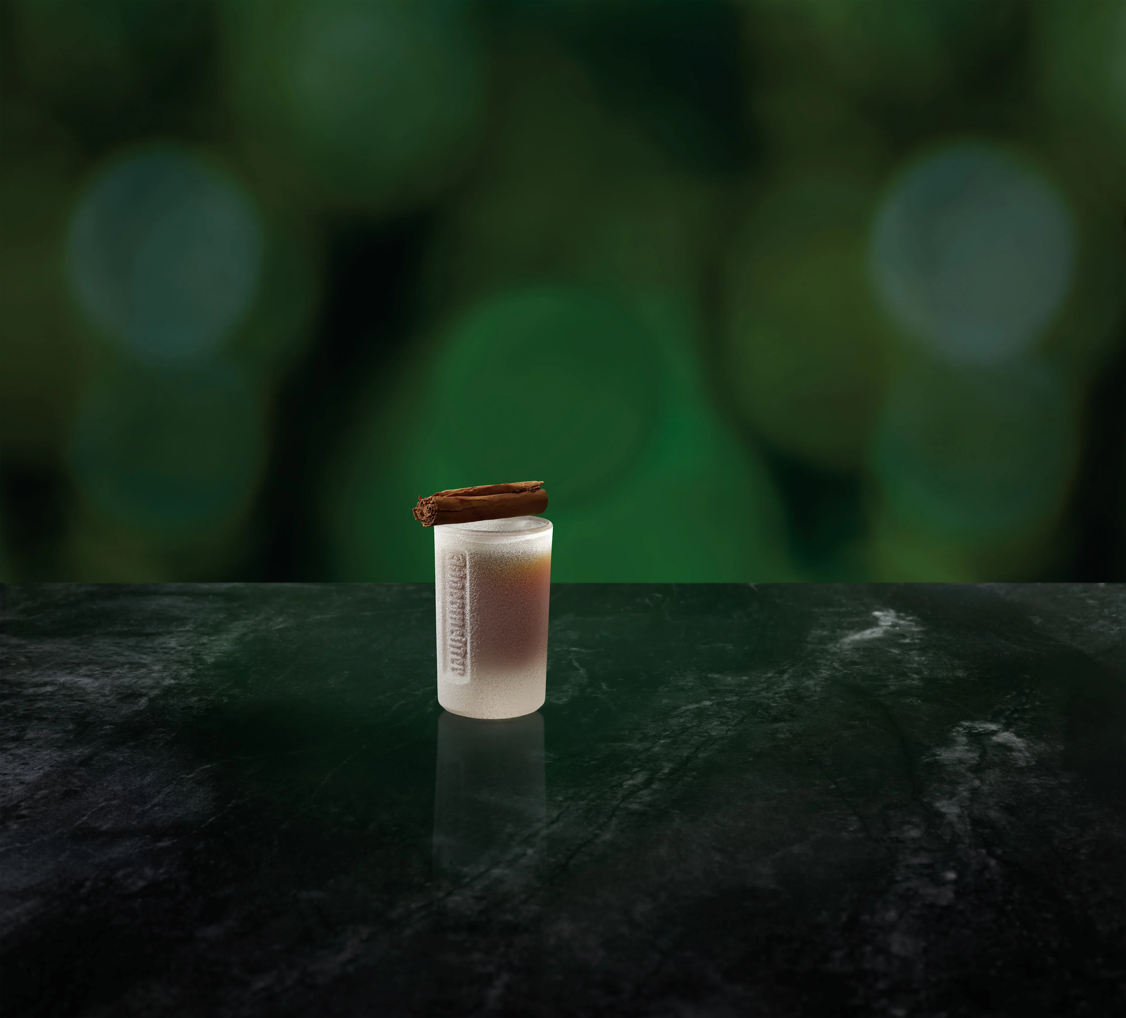 A shot glass of ice cold Jägermeister topped with cinnamon